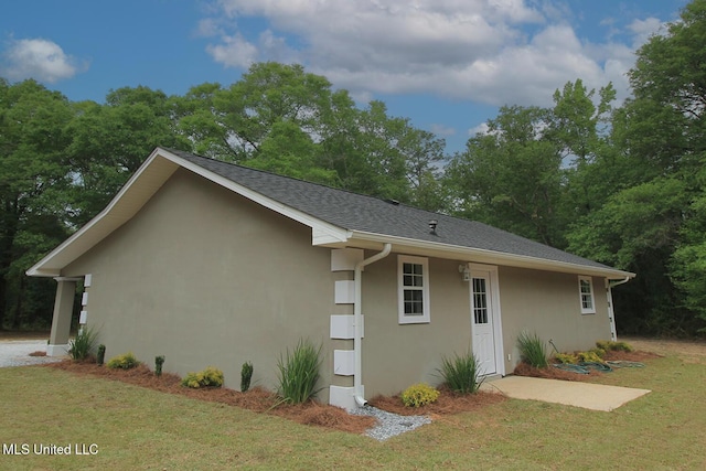 view of property exterior with stucco siding and a yard