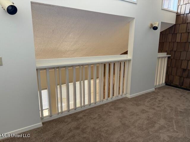 hallway featuring baseboards and carpet flooring