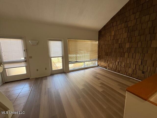 unfurnished living room featuring wood finished floors and vaulted ceiling