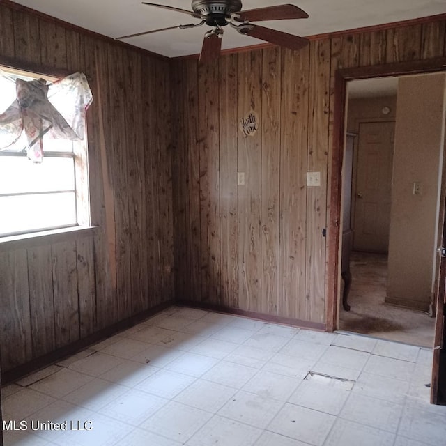 spare room featuring wooden walls and ceiling fan