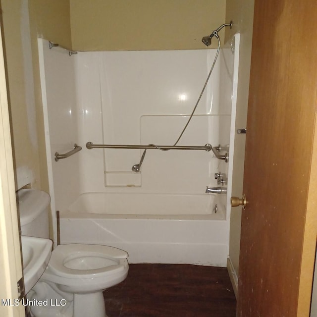 bathroom featuring washtub / shower combination, hardwood / wood-style flooring, and toilet