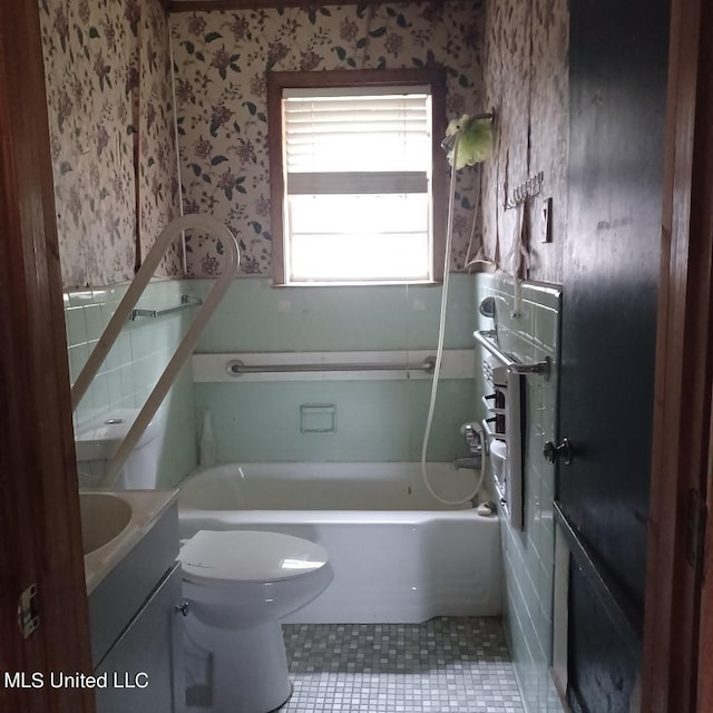 full bathroom with vanity, toilet, tile patterned floors, and washtub / shower combination