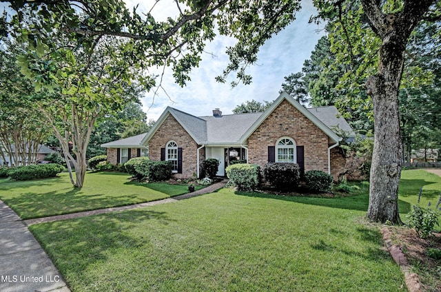 320 Woodhollow Cv, Brandon, MS 39047 - ranch-style house with brick siding, a front lawn, roof with shingles, and a chimney
