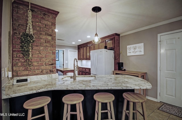 320 Woodhollow Cv, Brandon, MS 39047 - kitchen featuring freestanding refrigerator, a peninsula, crown molding, a breakfast bar, and tile patterned floors