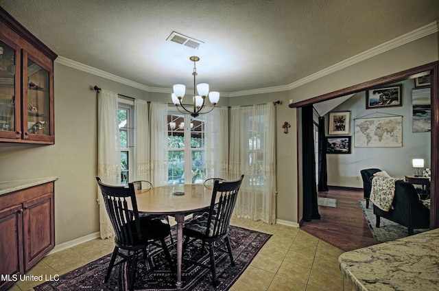 320 Woodhollow Cv, Brandon, MS 39047 - dining area with a chandelier, ornamental molding, light tile patterned floors, and a textured ceiling