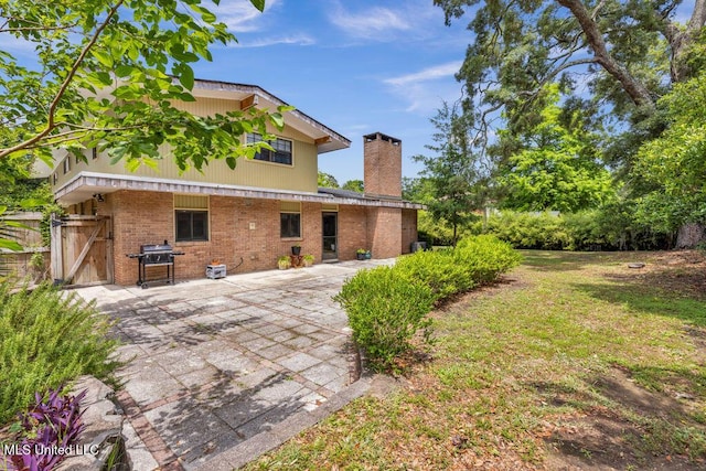 426 Donwood Pl, Biloxi, MS 39530 - rear view of property featuring a chimney, brick siding, and a patio