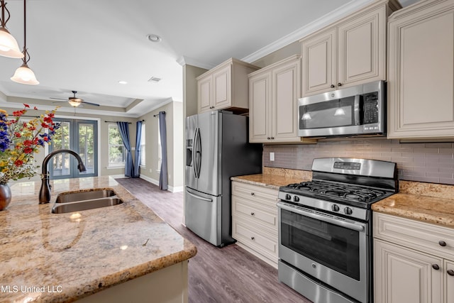 kitchen with a sink, ornamental molding, stainless steel appliances, and dark wood-style floors