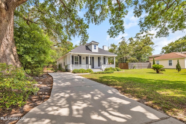 bungalow-style home with covered porch, a front yard, fence, concrete driveway, and a shingled roof
