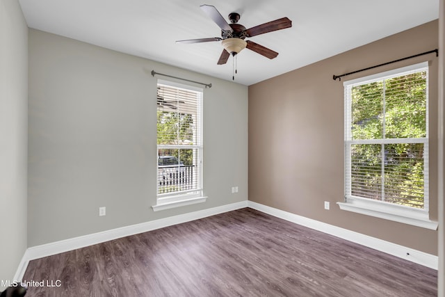 unfurnished room featuring plenty of natural light, baseboards, and wood finished floors