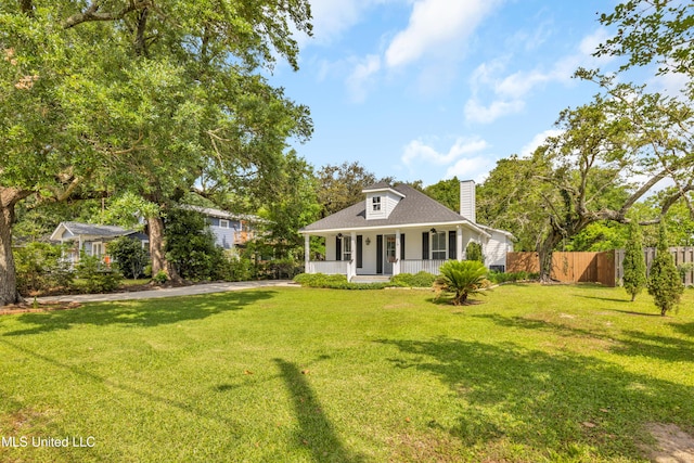 view of front of property with fence, covered porch, a front yard, roof with shingles, and a chimney