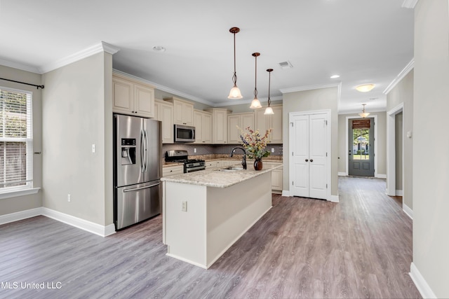 kitchen with a sink, a healthy amount of sunlight, stainless steel appliances, and cream cabinetry