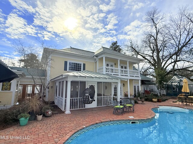 521 Holland Ave, Philadelphia, MS 39350 - rear view of house featuring a balcony, a patio area, and a sunroom