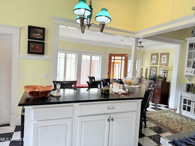 521 Holland Ave, Philadelphia, MS 39350 - kitchen featuring hanging light fixtures, ornamental molding, a kitchen island, white cabinetry, and a chandelier