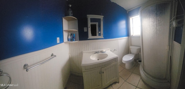 full bathroom with a wainscoted wall, a shower stall, toilet, and tile patterned floors