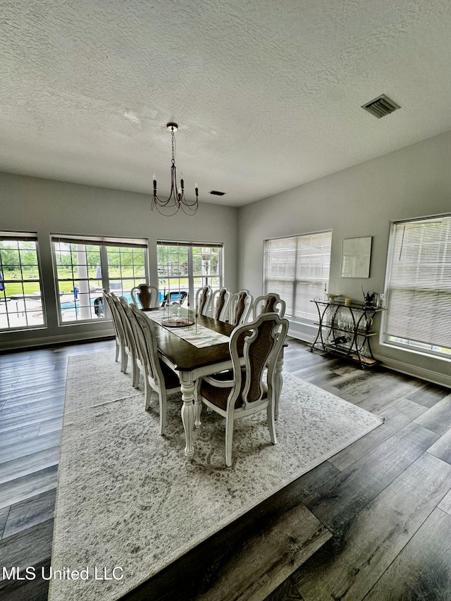 17500 Goff Farm Rd, Moss Point, MS 39562 - dining space with a chandelier, a textured ceiling, and wood finished floors
