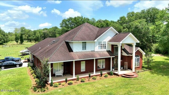 17500 Goff Farm Rd, Moss Point, MS 39562 - traditional home featuring covered porch, roof with shingles, and a front lawn