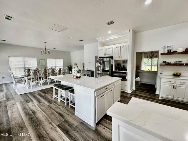 17500 Goff Farm Rd, Moss Point, MS 39562 - kitchen featuring stainless steel appliances, a chandelier, white cabinetry, a kitchen island, and dark wood-style floors