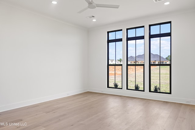 empty room featuring ceiling fan, light hardwood / wood-style floors, and ornamental molding