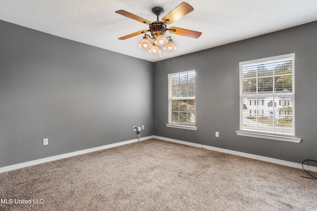 carpeted spare room featuring ceiling fan and a textured ceiling