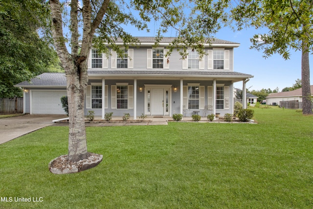 view of front of house with a front lawn, covered porch, and a garage