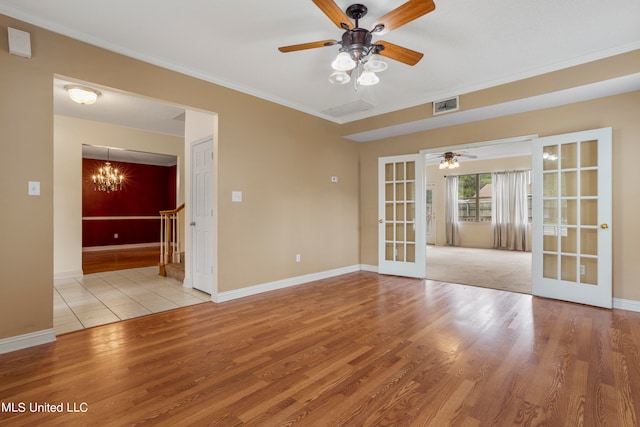 spare room with ornamental molding, french doors, light hardwood / wood-style flooring, and ceiling fan with notable chandelier