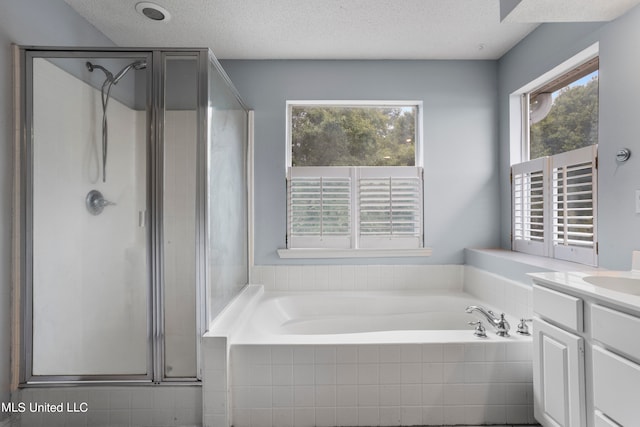 bathroom featuring vanity, a textured ceiling, and separate shower and tub