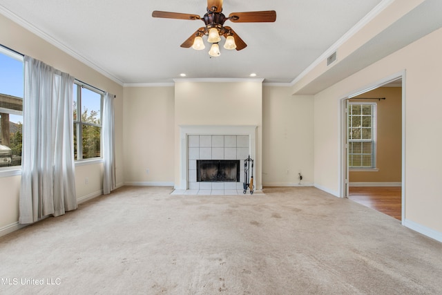 unfurnished living room featuring ornamental molding, light colored carpet, a fireplace, and ceiling fan