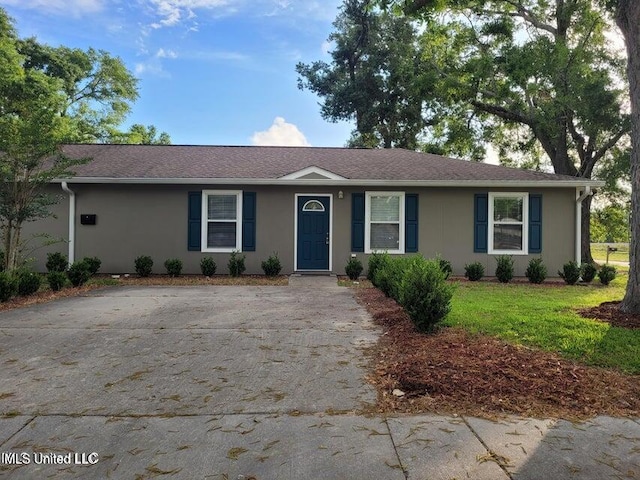 ranch-style house with stucco siding and a front yard