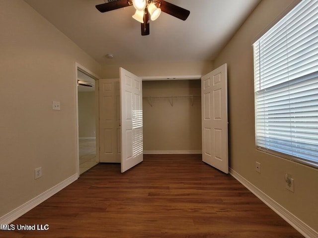 unfurnished bedroom with a closet, ceiling fan, baseboards, and wood finished floors