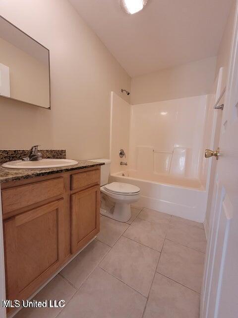 full bath featuring bathtub / shower combination, tile patterned floors, toilet, and vanity