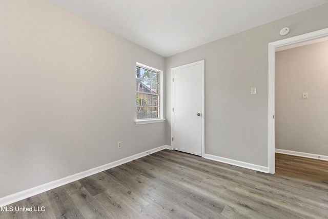 empty room featuring baseboards and wood finished floors