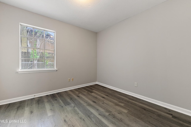 unfurnished room with dark wood-style flooring, baseboards, and a textured ceiling