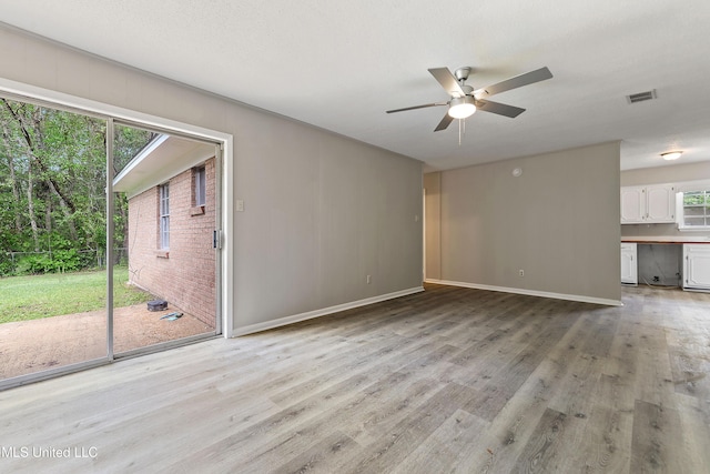 unfurnished living room featuring baseboards, visible vents, light wood-type flooring, and a ceiling fan