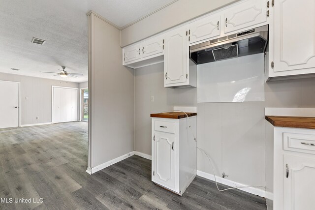 kitchen with a textured ceiling, a ceiling fan, white cabinets, visible vents, and dark wood finished floors