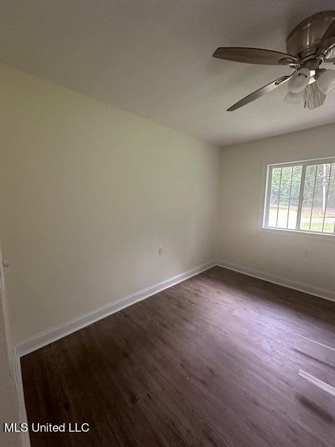 unfurnished room with ceiling fan and dark hardwood / wood-style flooring