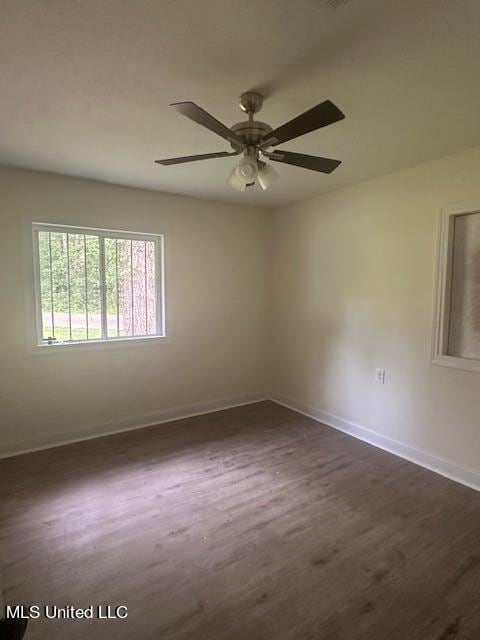 empty room with ceiling fan and dark hardwood / wood-style flooring