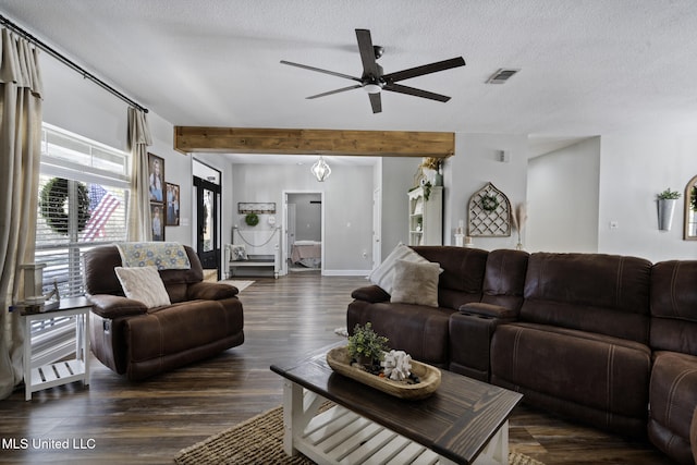 living room featuring visible vents, beam ceiling, dark wood-type flooring, a textured ceiling, and ceiling fan