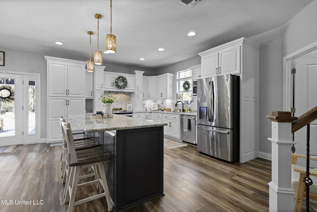 kitchen with stainless steel appliances, dark wood-style flooring, and white cabinetry