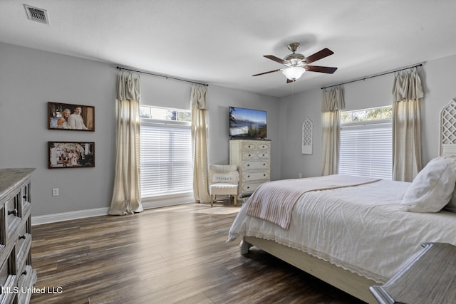 bedroom featuring dark wood finished floors, multiple windows, baseboards, and visible vents