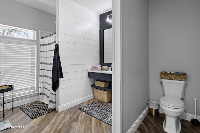 full bath with a shower with curtain, toilet, baseboards, and wood finished floors