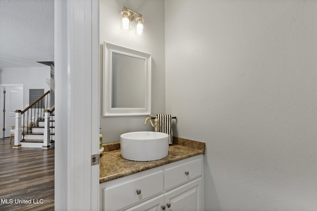 bathroom featuring vanity, wood finished floors, and a textured ceiling