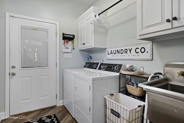 clothes washing area featuring cabinet space, dark wood-style flooring, washing machine and dryer, and a sink