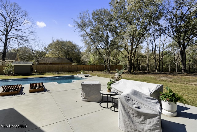 view of pool featuring a fenced backyard, a fenced in pool, an outbuilding, and a patio