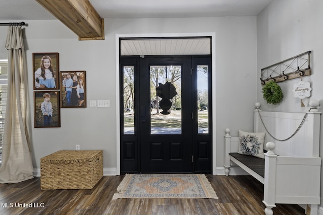 foyer with beam ceiling, dark wood-type flooring, and baseboards