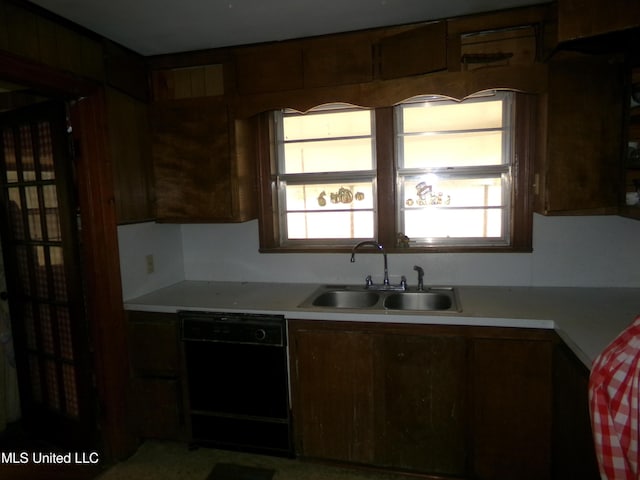 kitchen featuring dishwasher, light countertops, and a sink