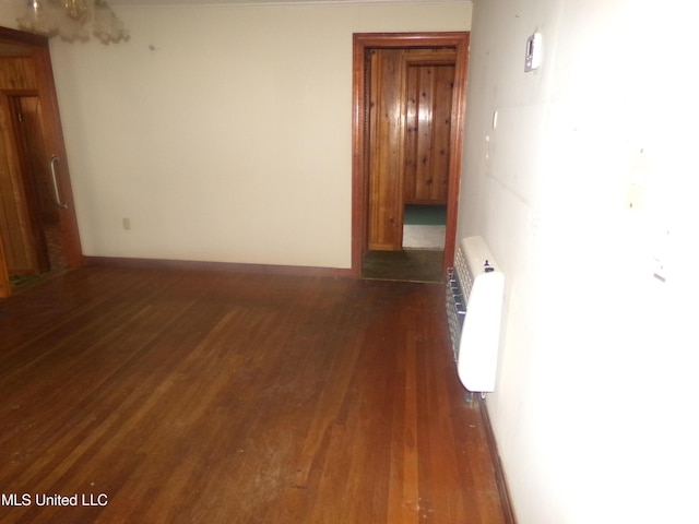 interior space with heating unit, dark wood-style floors, and baseboards