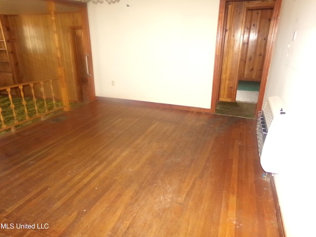 empty room with radiator heating unit and wood finished floors