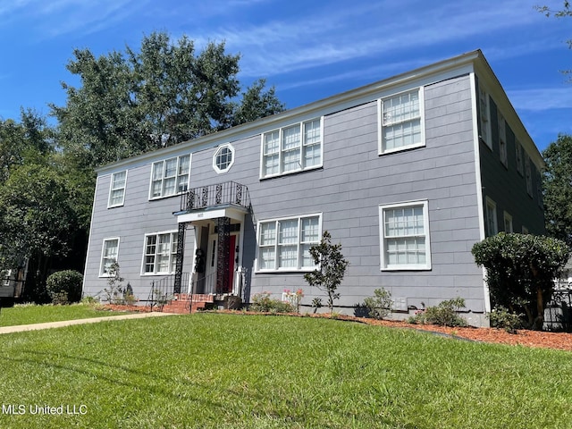 colonial house featuring a front lawn