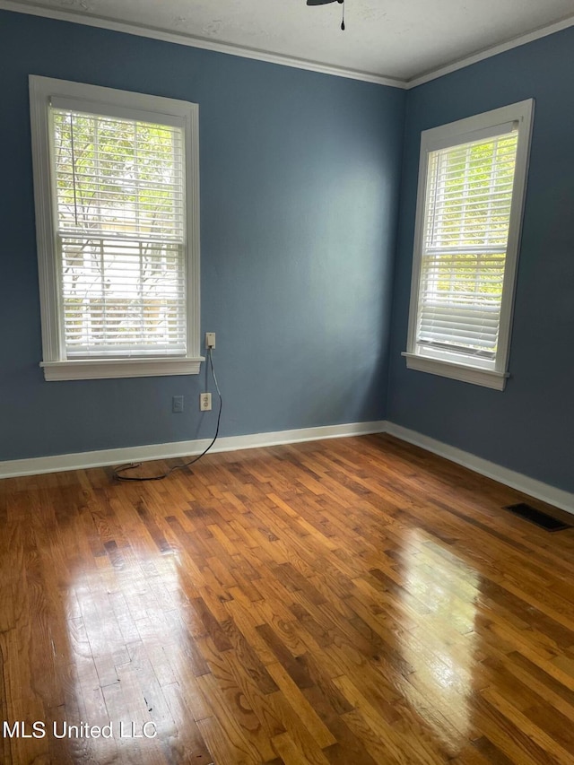 spare room featuring ceiling fan, wood-type flooring, and ornamental molding