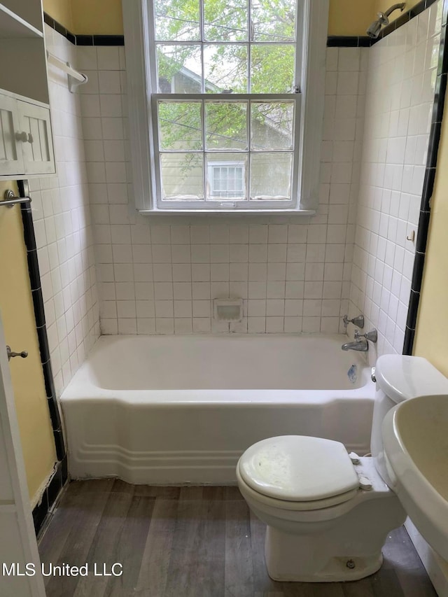 full bathroom featuring hardwood / wood-style flooring, sink, toilet, and tiled shower / bath combo